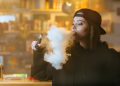 Confused vaping woman  - Stock Image