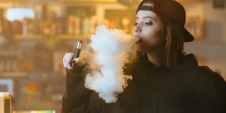 Confused vaping woman  - Stock Image